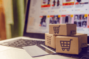 Small shopping cart boxes with a credit card on top of a laptop online shopping with ecommerce