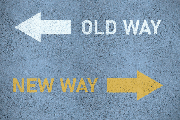 Sign with the left arrow saying old way and yellow right arrow pointed that says new way.
