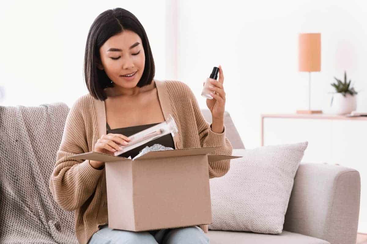 woman unboxing her ecommerce shopping purchases on the couch.