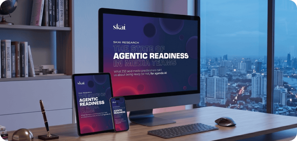 Un écran d'ordinateur, une tablette et un smartphone posés sur un bureau affichent le rapport intitulé « The State of Agentic Readiness in Media Teams » (L'état de préparation des équipes médias à l'agentique), publié par Skai . On aperçoit la silhouette d'une ville à travers la fenêtre en arrière-plan.