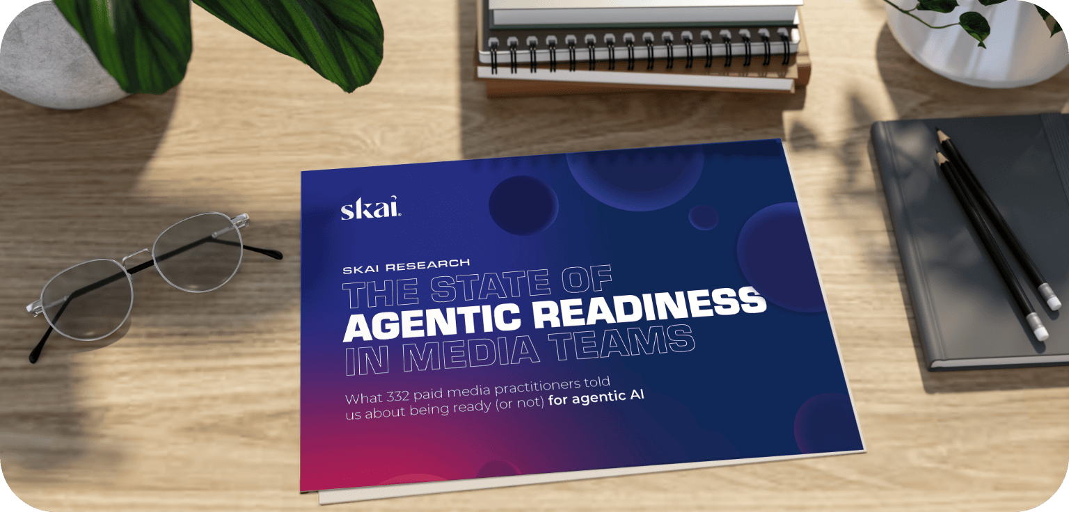 A booklet titled The State of Agentic Readiness in Media Teams lies on a desk with glasses, a pen, a notebook, and a potted plant nearby.